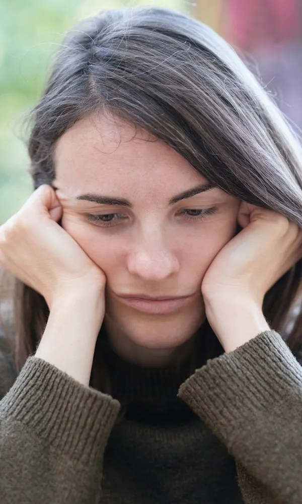 Woman resting her hands against her face, weighed down by constant worry — generalized anxiety disorder therapy in Los Angeles