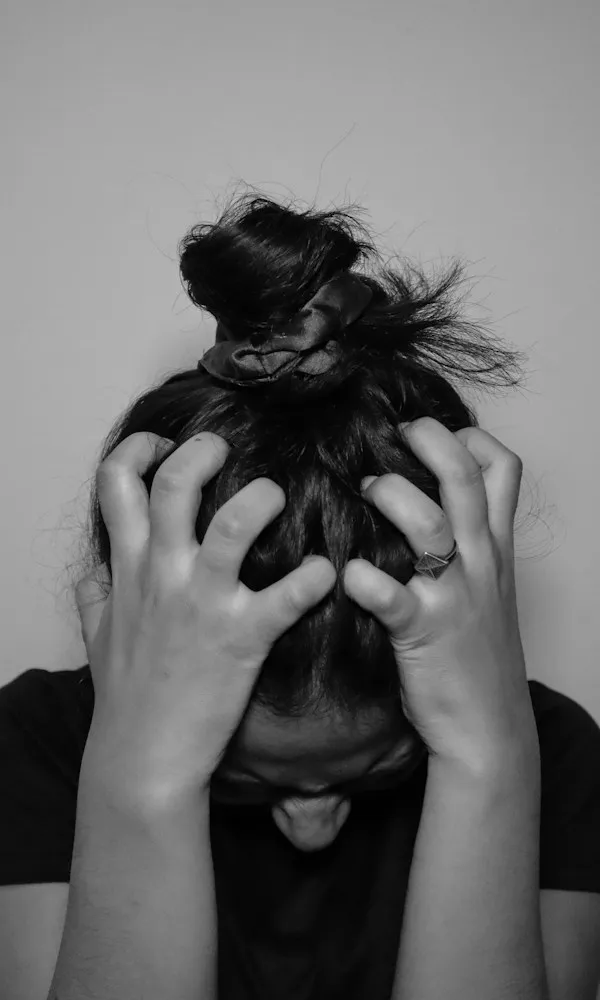 Black and white close-up of hands clenched in hair as panic takes hold — panic attack and panic disorder therapy in Los Angeles