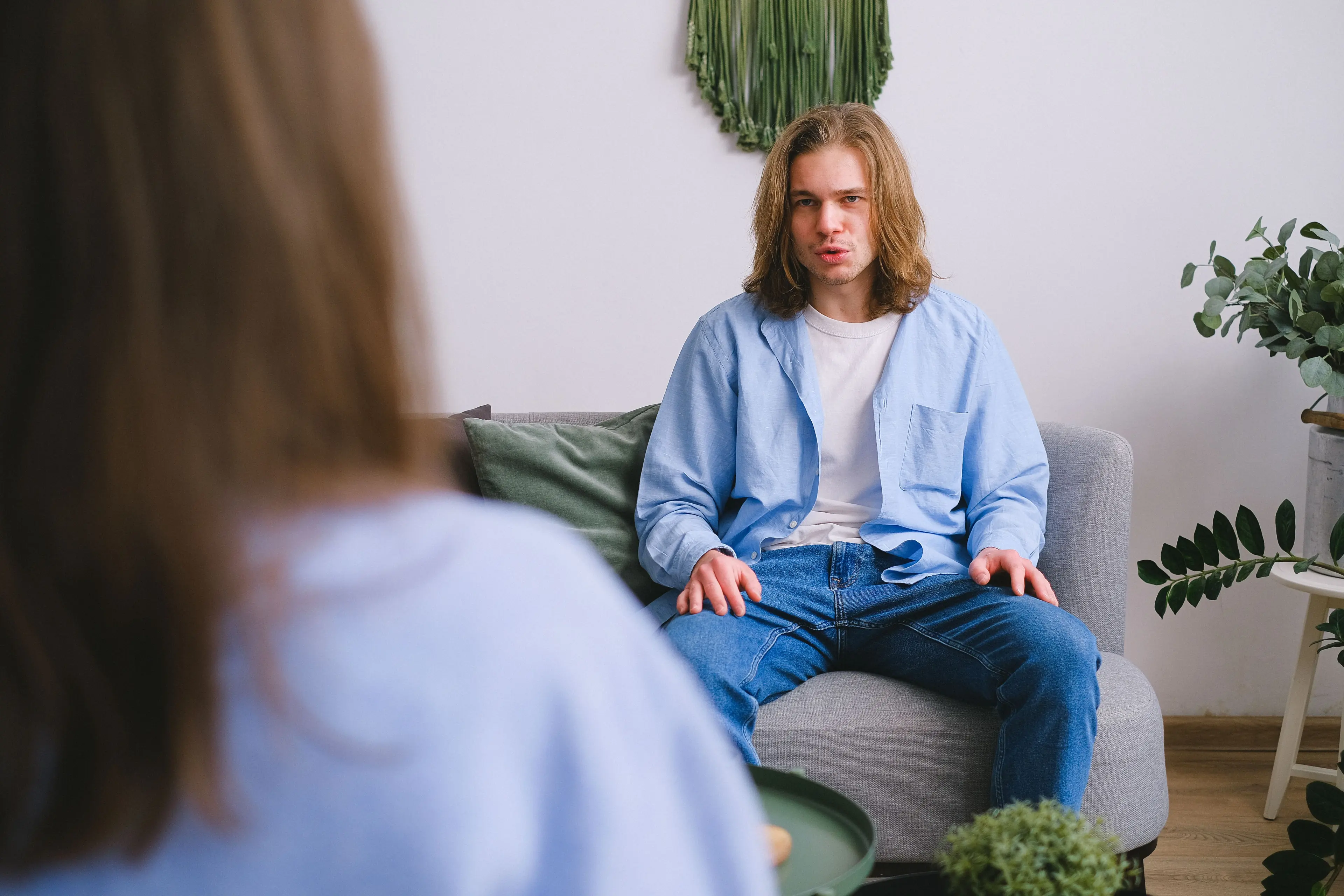 A young man talking with his therapist on a sofa — individual therapy in Los Angeles