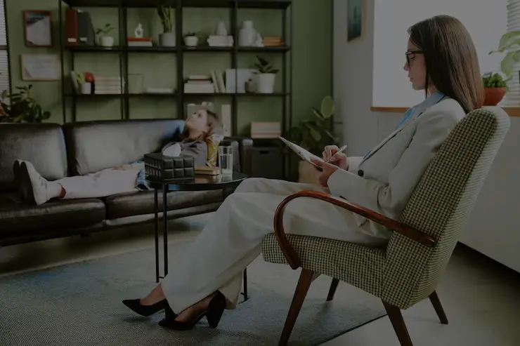 A therapist in Los Angeles conducting a one-on-one therapy session with a client lying on a couch.