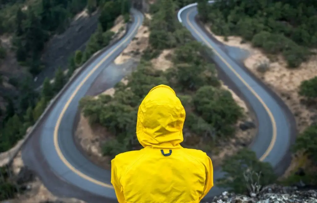A person standing at a crossroads, symbolizing the struggle between self-doubt and self-trust.