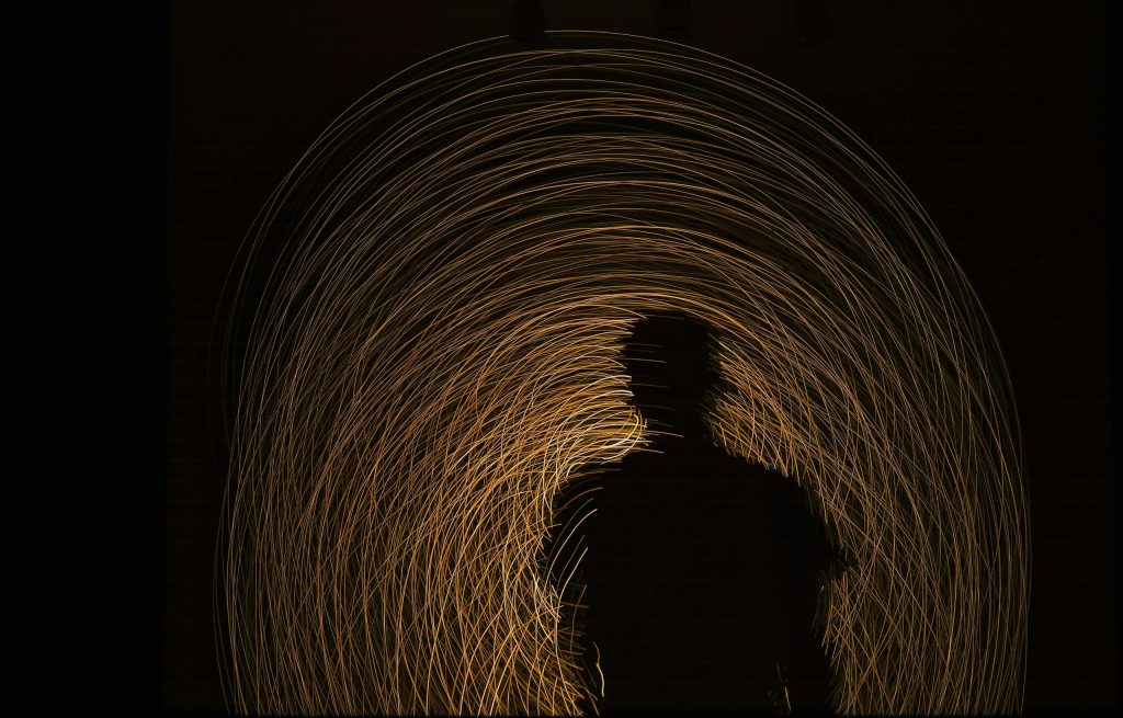 A man standing alone in a glowing tunnel, symbolizing the journey through past, present, and future. The transtemporal now