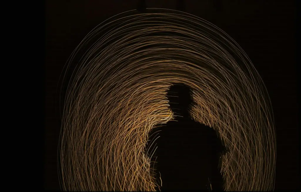 A man standing alone in a glowing tunnel, symbolizing the journey through past, present, and future. The transtemporal now